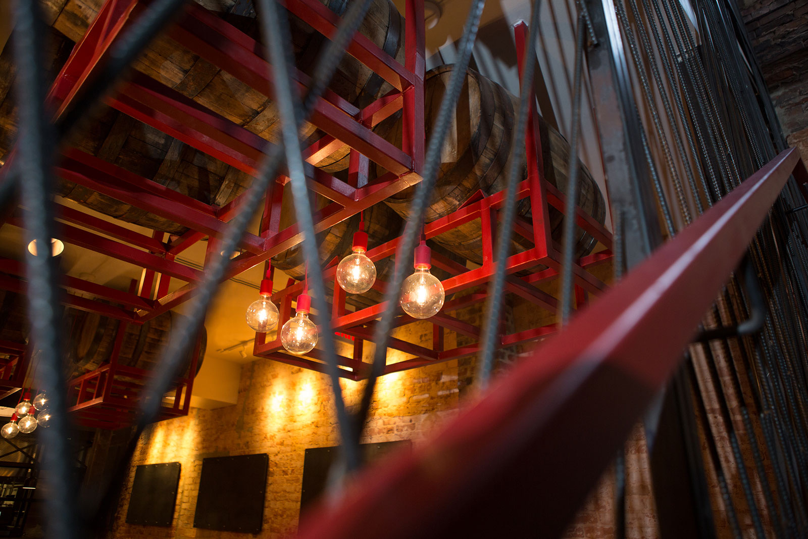 Bourbon barrels and red-steel light fixtures overhead